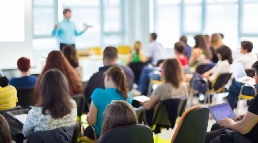 Teacher lecturing students in large classroom