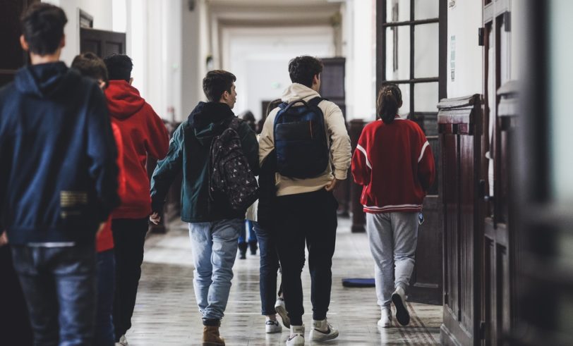 Teens walking down school hallway