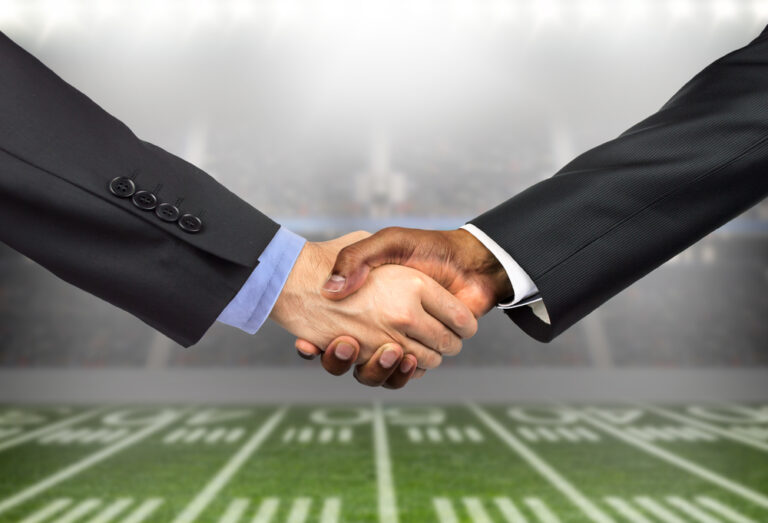 Handshake superimposed over football field