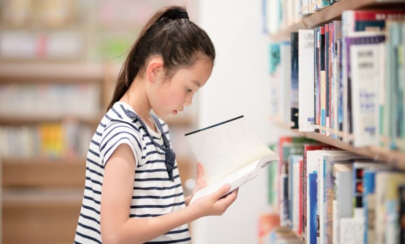 Student reading book, third-grade retention, retention policies, learning to read, literacy tests